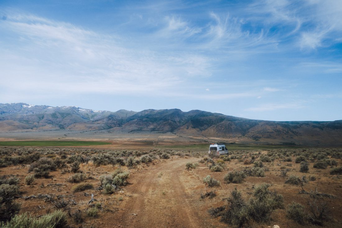 A van crossing a wide basin under high midday sky