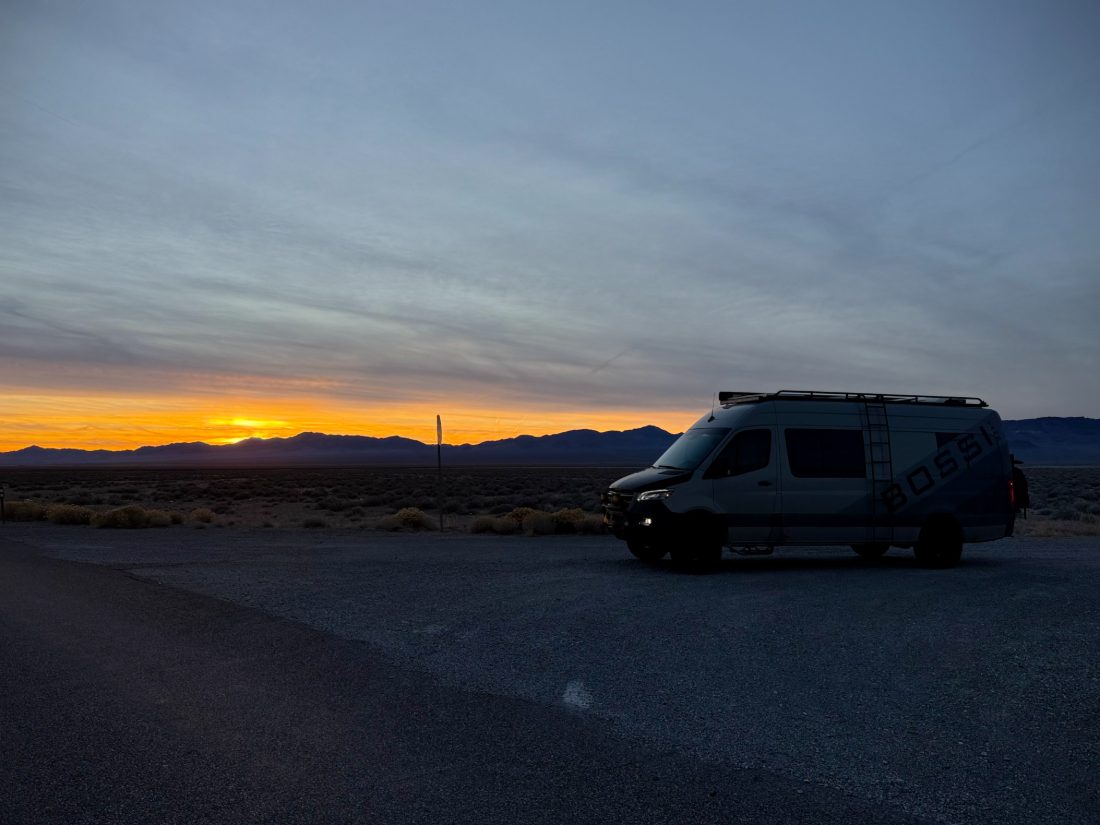 The open door of a van facing a low sun