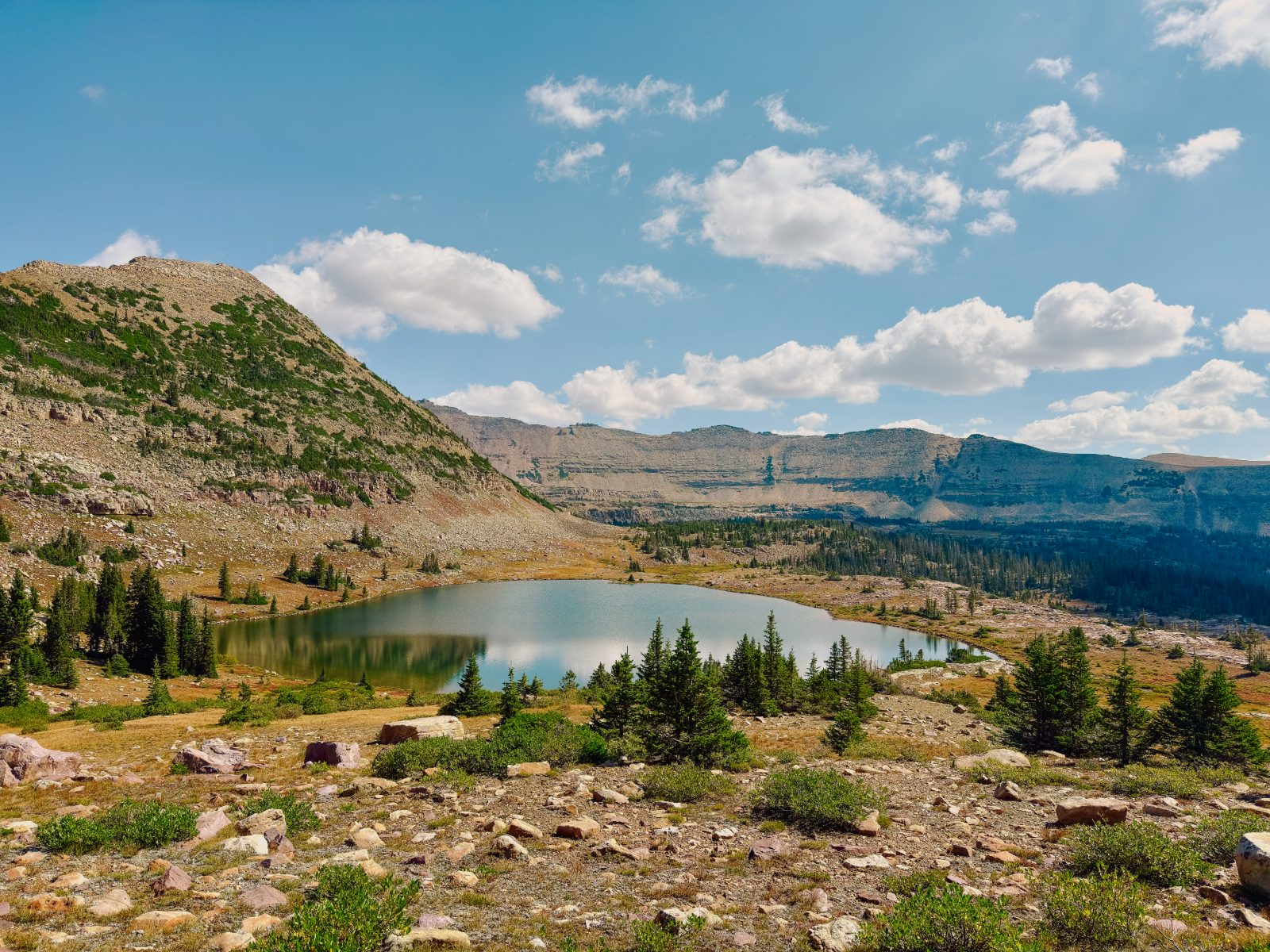 A still alpine lake below bare rock