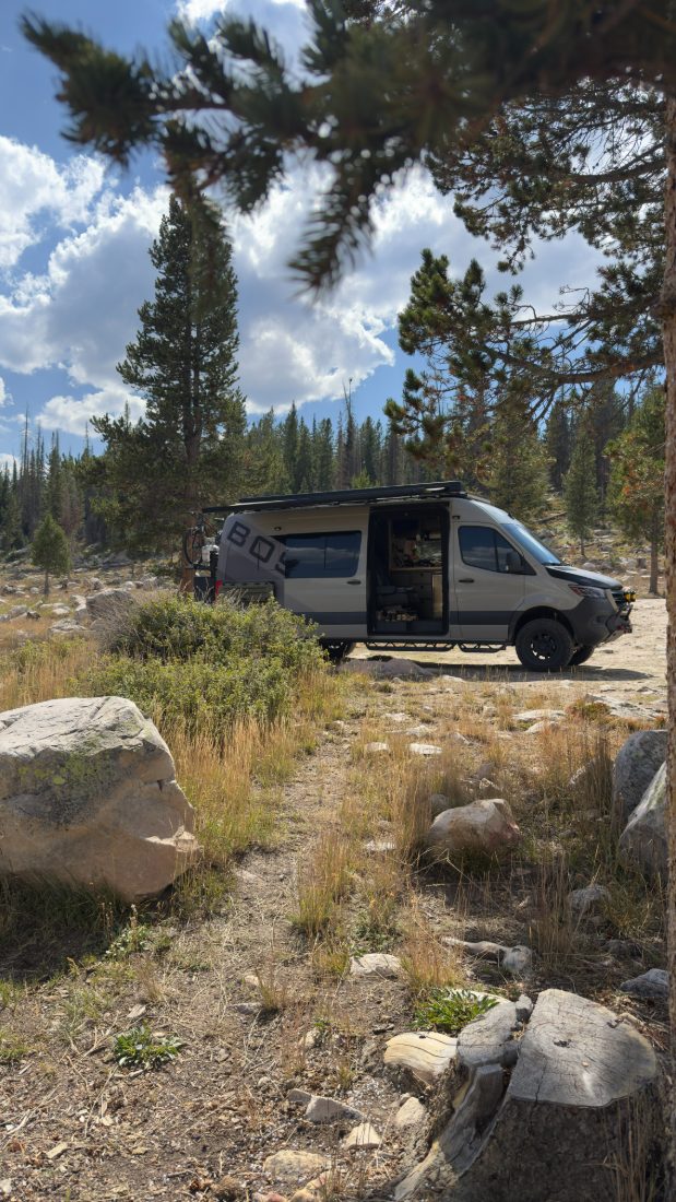A van pulled off among tall timber